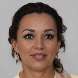 Joyful latino adult female with medium  brown hair and brown eyes