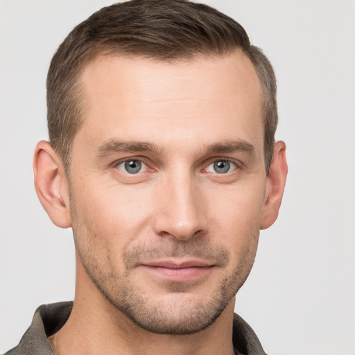 Joyful white young-adult male with short  brown hair and grey eyes