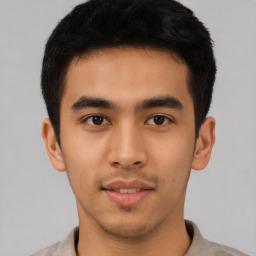 Joyful latino young-adult male with short  brown hair and brown eyes