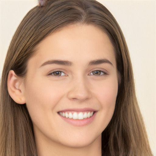 Joyful white young-adult female with long  brown hair and brown eyes