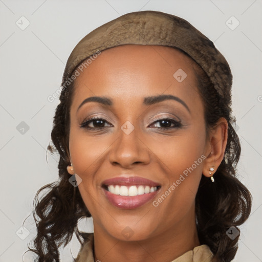 Joyful black young-adult female with long  brown hair and brown eyes