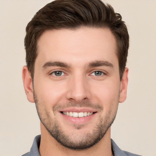 Joyful white young-adult male with short  brown hair and grey eyes