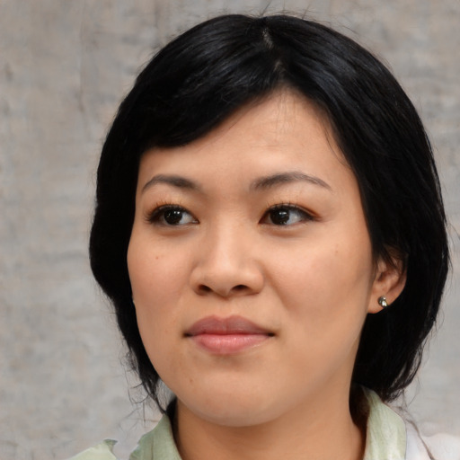 Joyful asian young-adult female with medium  black hair and brown eyes