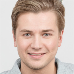 Joyful white young-adult male with short  brown hair and grey eyes