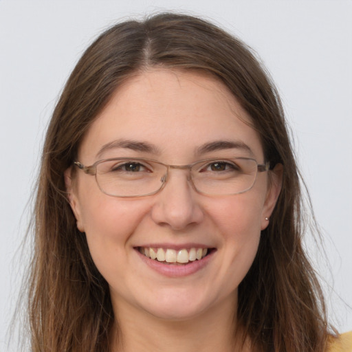 Joyful white adult female with long  brown hair and grey eyes