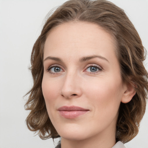 Joyful white young-adult female with medium  brown hair and blue eyes