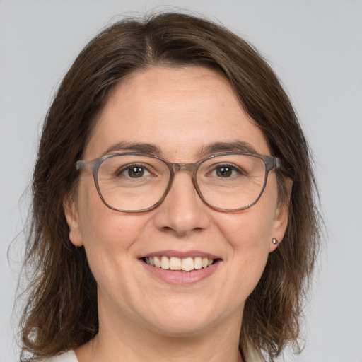 Joyful white adult female with medium  brown hair and green eyes