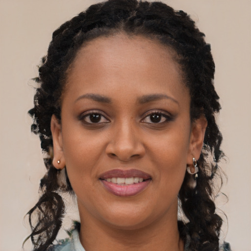 Joyful black young-adult female with long  black hair and brown eyes