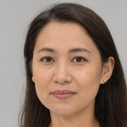 Joyful white adult female with long  brown hair and brown eyes