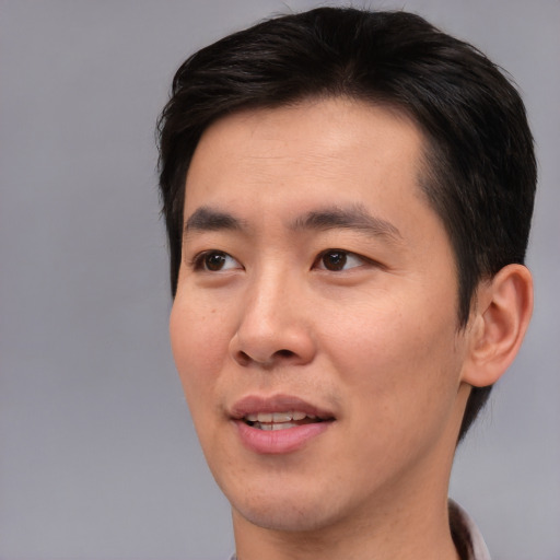 Joyful asian young-adult male with short  brown hair and brown eyes