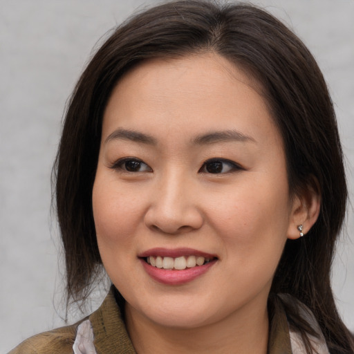 Joyful asian young-adult female with long  brown hair and brown eyes