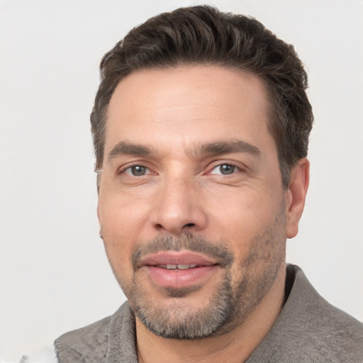 Joyful white adult male with short  brown hair and brown eyes