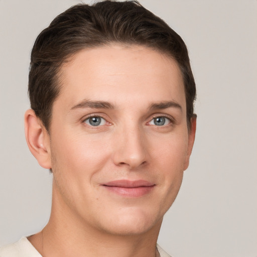 Joyful white young-adult male with short  brown hair and grey eyes