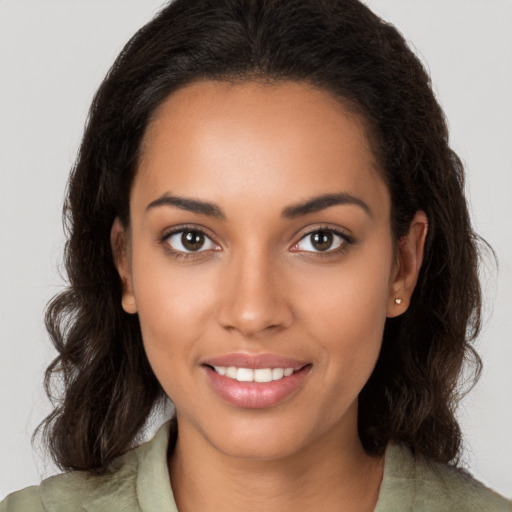 Joyful black young-adult female with long  brown hair and brown eyes