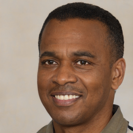 Joyful black young-adult male with short  black hair and brown eyes