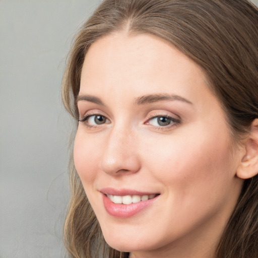 Joyful white young-adult female with long  brown hair and grey eyes