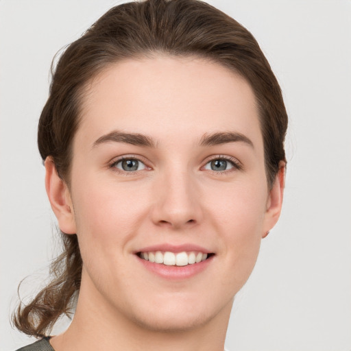 Joyful white young-adult female with short  brown hair and grey eyes