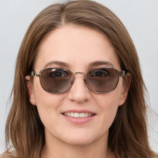 Joyful white young-adult female with long  brown hair and blue eyes