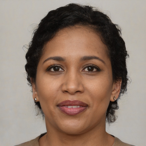 Joyful black adult female with short  brown hair and brown eyes