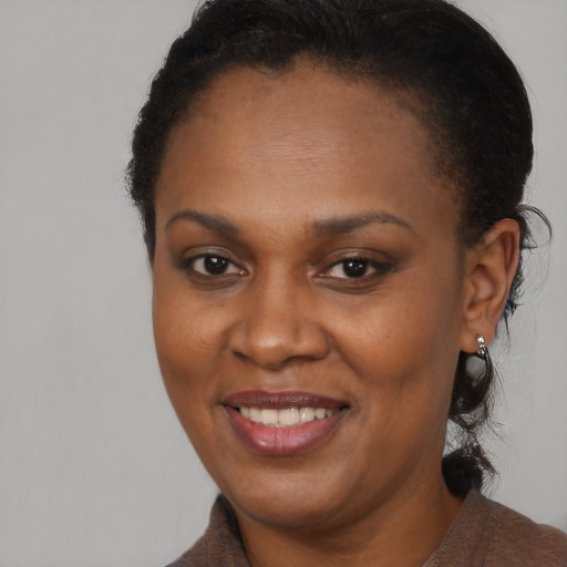 Joyful black adult female with short  brown hair and brown eyes
