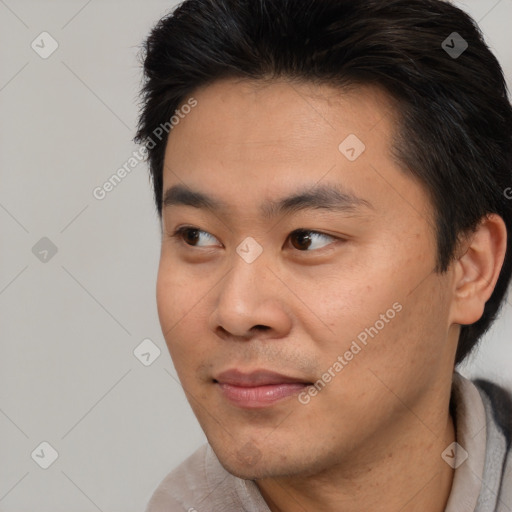 Joyful asian young-adult male with short  black hair and brown eyes