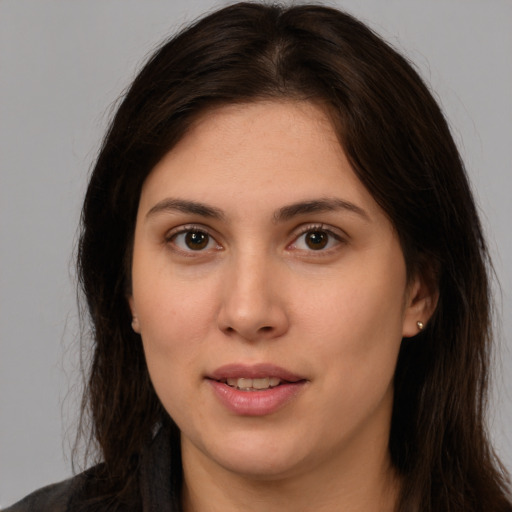 Joyful white young-adult female with long  brown hair and brown eyes