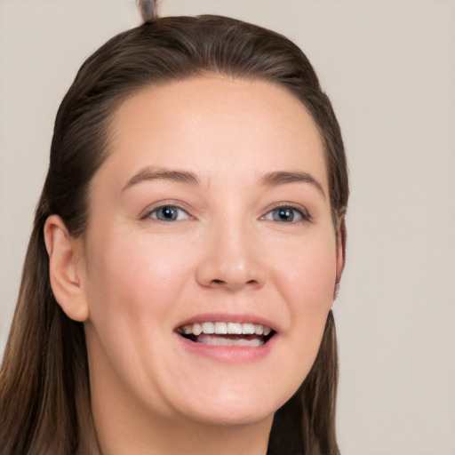 Joyful white young-adult female with long  brown hair and grey eyes