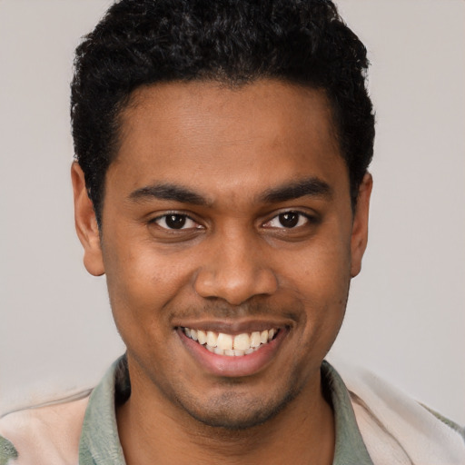 Joyful black young-adult male with short  brown hair and brown eyes