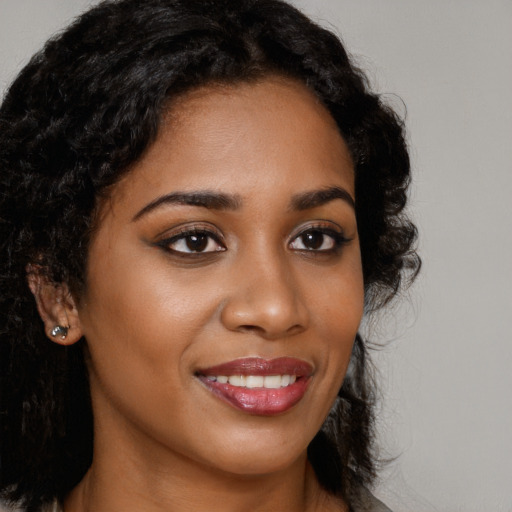 Joyful black young-adult female with long  brown hair and brown eyes