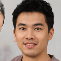 Joyful asian young-adult male with short  black hair and brown eyes