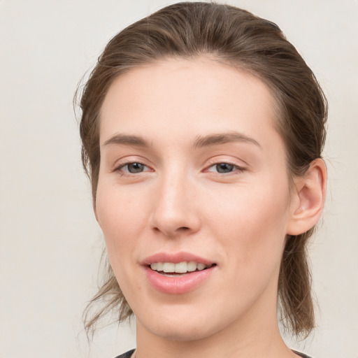 Joyful white young-adult female with medium  brown hair and grey eyes