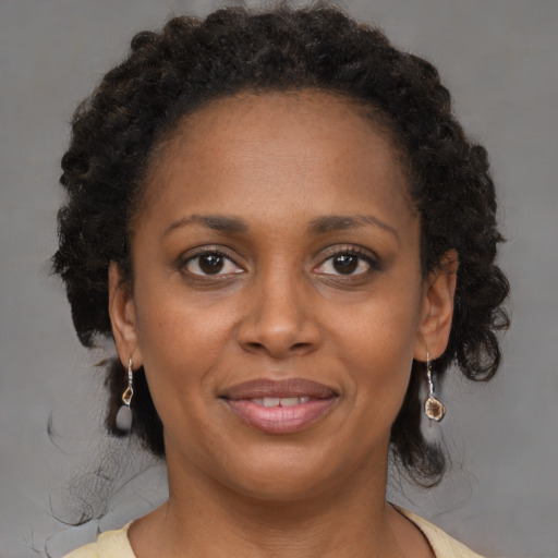 Joyful black adult female with medium  brown hair and brown eyes