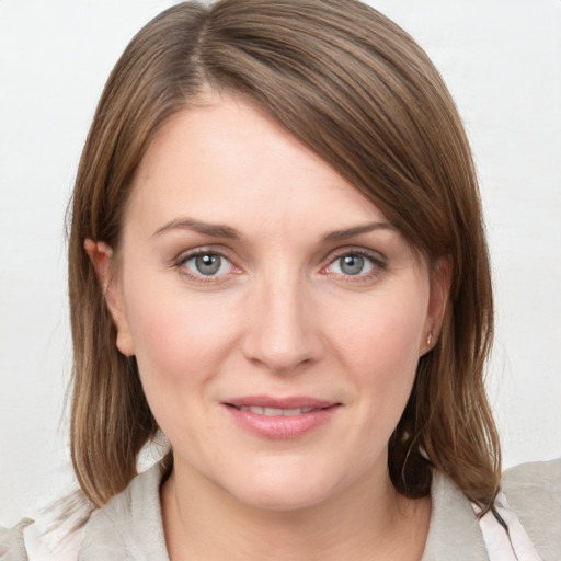 Joyful white young-adult female with medium  brown hair and grey eyes