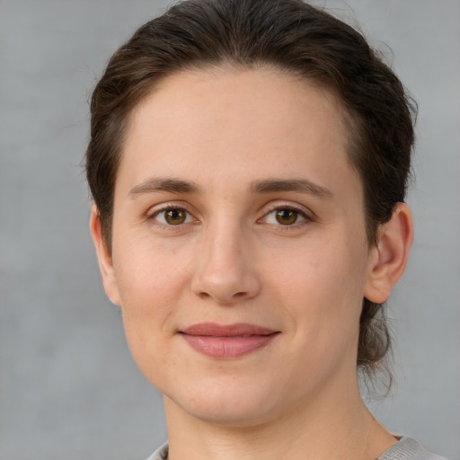Joyful white young-adult female with short  brown hair and grey eyes