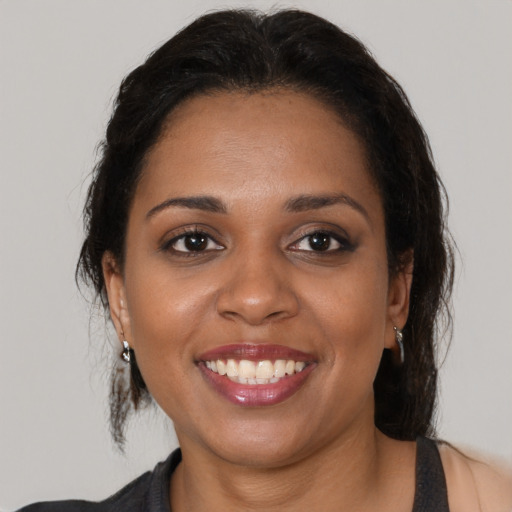 Joyful black young-adult female with medium  brown hair and brown eyes