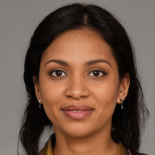 Joyful black young-adult female with long  black hair and brown eyes