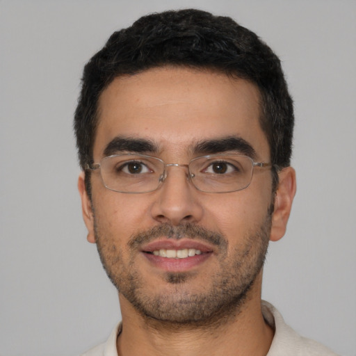 Joyful latino young-adult male with short  black hair and brown eyes