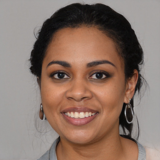 Joyful black young-adult female with medium  black hair and brown eyes