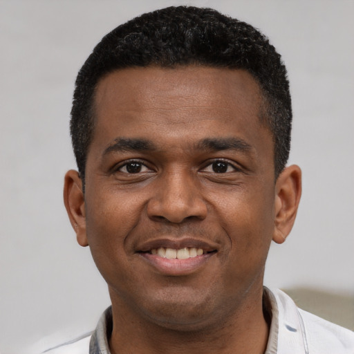 Joyful latino young-adult male with short  brown hair and brown eyes