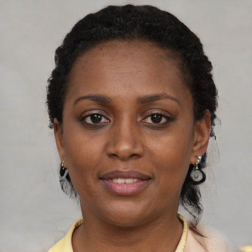 Joyful black young-adult female with short  brown hair and brown eyes