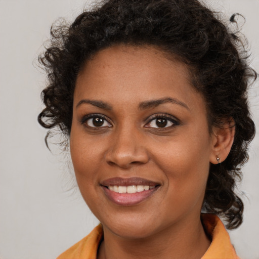 Joyful black young-adult female with long  brown hair and brown eyes