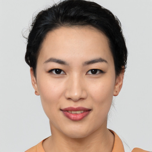 Joyful asian young-adult female with short  black hair and brown eyes