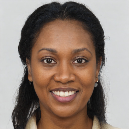 Joyful black young-adult female with long  brown hair and brown eyes