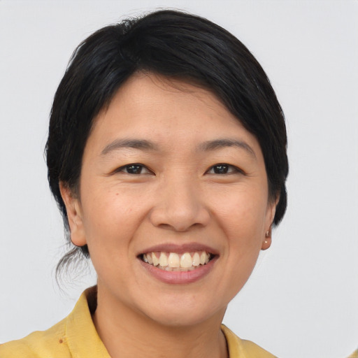 Joyful asian young-adult female with medium  black hair and brown eyes