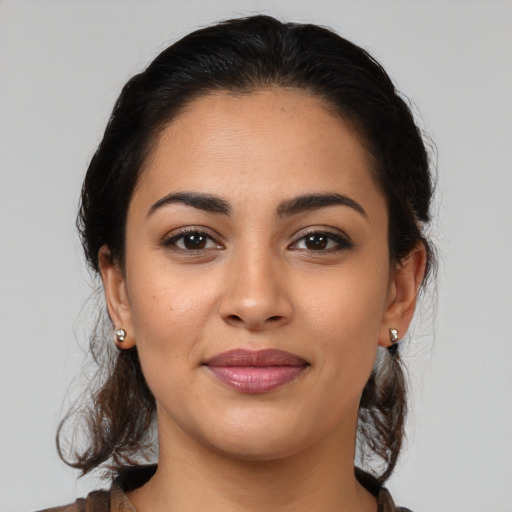 Joyful latino young-adult female with medium  brown hair and brown eyes