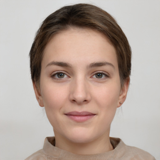 Joyful white young-adult female with short  brown hair and grey eyes