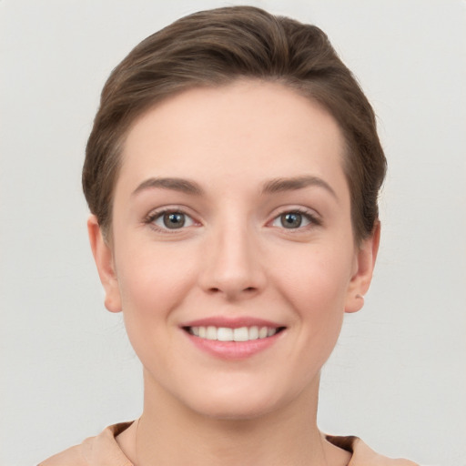 Joyful white young-adult female with short  brown hair and grey eyes