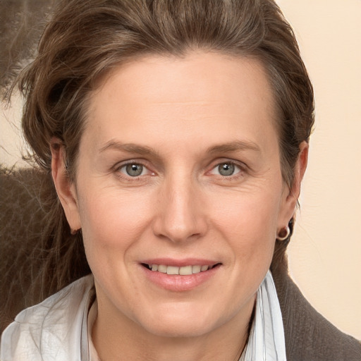 Joyful white adult female with medium  brown hair and grey eyes