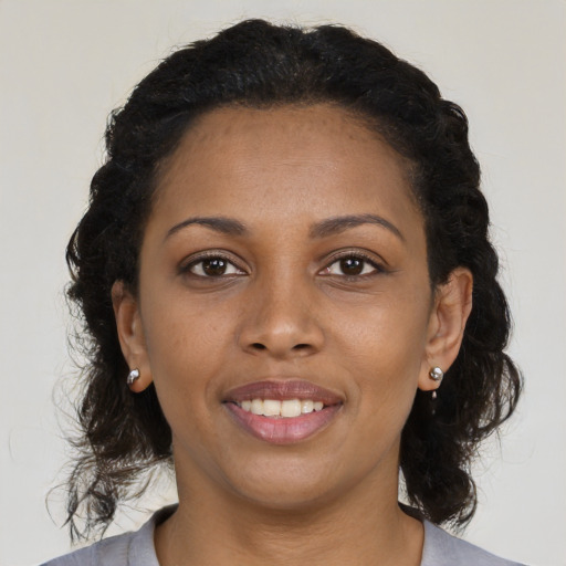 Joyful black young-adult female with medium  brown hair and brown eyes