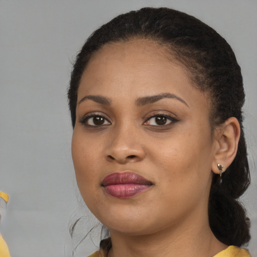 Joyful black young-adult female with medium  black hair and brown eyes